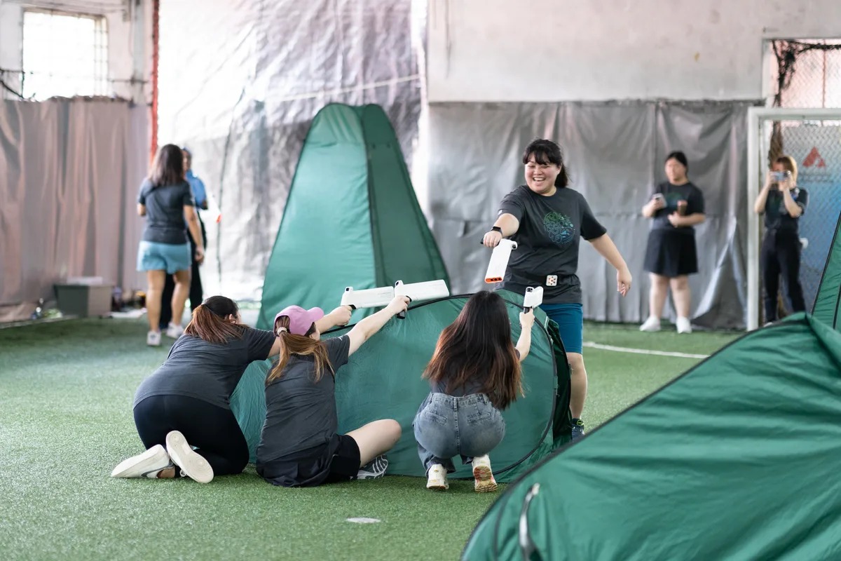 Laser Tag players coordinating around inflatable cover during a Cohesion team event