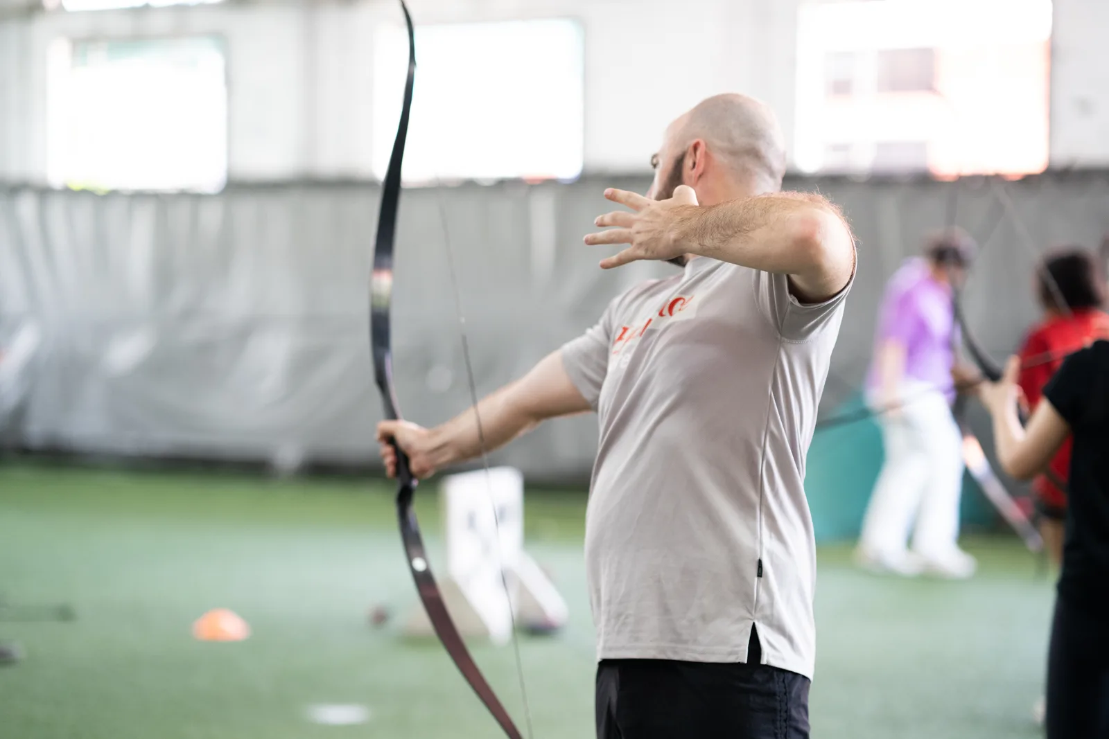 Participant taking part in an indoor Cohesion archery tag session