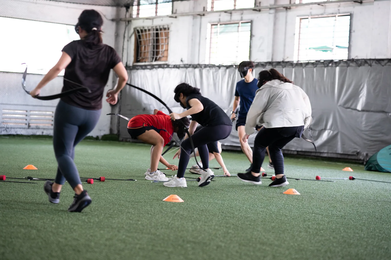 Archery Tag participants aiming foam arrows during a Cohesion activity