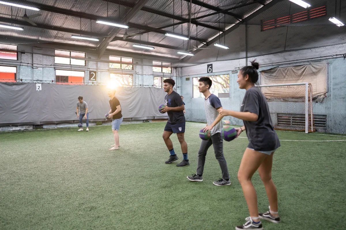 Participants playing Dodgeball in an indoor venue during a Cohesion team building activity
