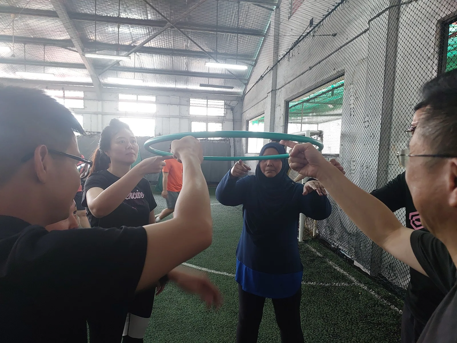 Land Transport Authority participants coordinating around a ring during a collaborative team-building activity.
